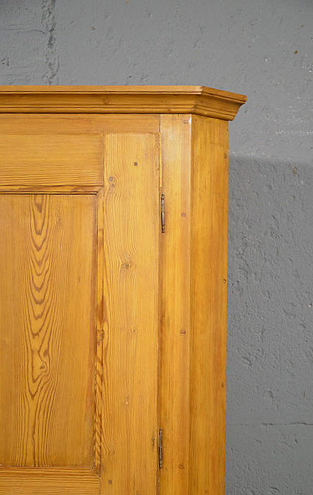 Detail der oberen T&uuml;r und der Kranzleiste des schlichten 2-t&uuml;rigen Biedermeier Eckschranks aus massivem Kiefernholz