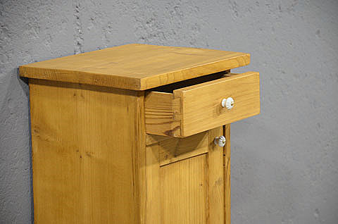 Geöffnete Schublade mit Porzellanknopf des restaurierten Nachtschranks aus dem Jugendstil. Wir liefern zuverlässig, kostengünstig und persönlich – deutschlandweit bis in Ihr Zuhause. Nach Terminvereinbarung können Sie dieses Möbelstück in unserem Möbellager in Bargfeld-Stegen besichtigen.