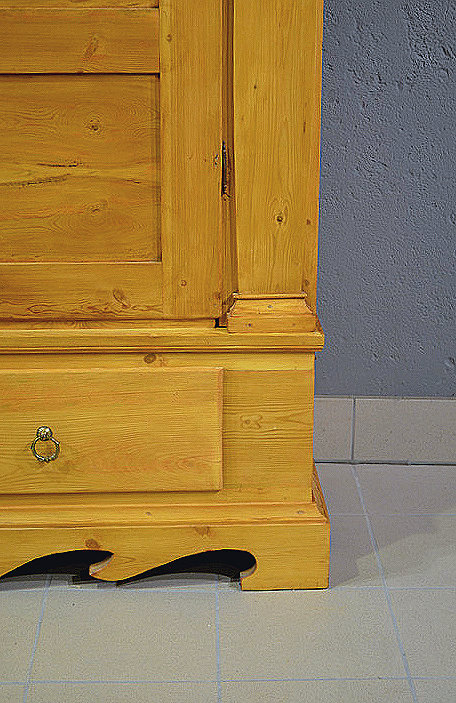 Detailaufnahme des formschön gestalteten Sockels mit elegantem Profil an Front und Seitenteilen, verleiht dem breiten Schrank ein harmonisches Erscheinungsbild. 