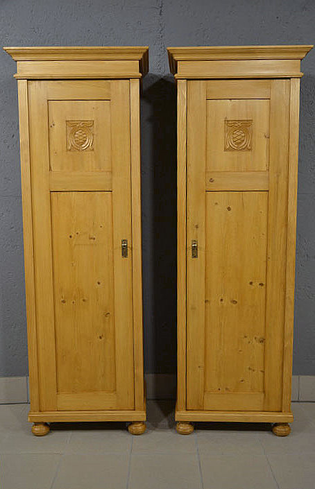 Gesamtansicht der beiden 1-türigen Jugendstil-Kleiderschränke mit Türanschlag links und rechts. restauriert und honigfarben gewachst. Nach Terminvereinbarung können Sie diese Möbelstücke gerne in unserem Möbellager in Bargfeld-Stegen besichtigen. Wir liefern zuverlässig, kostengünstig und persönlich – deutschlandweit bis in Ihr Zuhause.