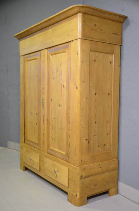 Rechte Seitenansicht des Biedermeier Kleiderschranks aus Dänemark, massive Kiefer, zerlegbar und wohnfertig restauriert. Klare Linien und eckige Füße in typischer Biedermeier-Form. Persönliche Lieferung und Aufbau durch uns deutschlandweit.