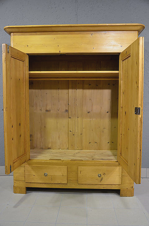 Innenansicht des antiken Biedermeier Kleiderschranks mit Holzkleiderstange über die gesamte Breite und einem Einlegeboden. Optimale Bügeltiefe von 51 cm, ideal als Garderobenschrank. Persönlicher Aufbau vor Ort und Lieferung deutschlandweit.