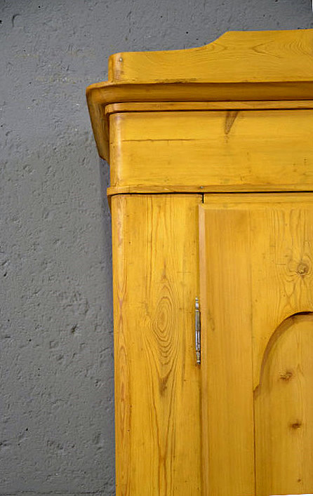 Oberer Kranzbereich und Türausschnitt mit geschwungenen Formen – typisch für das Biedermeier um 1840. Die Honigtönung unterstreicht die ruhige Eleganz.