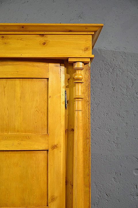 Detail der bauchigen Türen mit Kassettenfüllungen und kleiner Ausschnitt der Schublade des antiken Kleiderschrankes aus der Gründerzeit.