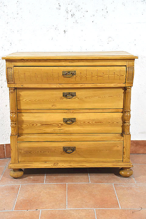 Frontansicht einer stilvollen antiken Gruenderzeit Kommode aus Daenemark um 1880 mit vier Schubladen, Halbsaeulen und dekorativen Details aus massivem Kiefernholz im warmen Honigton. Wohnfertig restauriert. Wir liefern zuverlaessig, kostenguenstig und persoenlich deutschlandweit bis in Ihr Zuhause. Nach Terminvereinbarung koennen Sie dieses Moebelstueck gerne in unserem Moebellager in Bargfeld Stegen besichtigen.