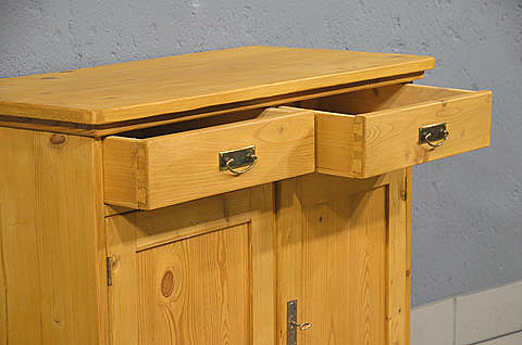 Geoeffnete Schublade der antiken Kiefer Kommode mit Griffen aus dem Jugendstil. Wir liefern zuverlässig, kostengünstig und persönlich – deutschlandweit bis in Ihr Zuhause. Nach Terminvereinbarung können Sie dieses Möbelstück in unserem Möbellager in Bargfeld-Stegen besichtigen.