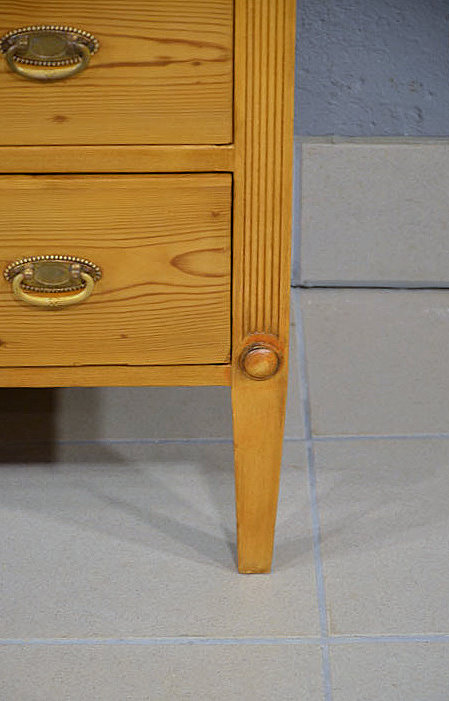 Detail eines charakteristischen Spitzbeins der schlichten antiken Kommode aus massiver Kiefer