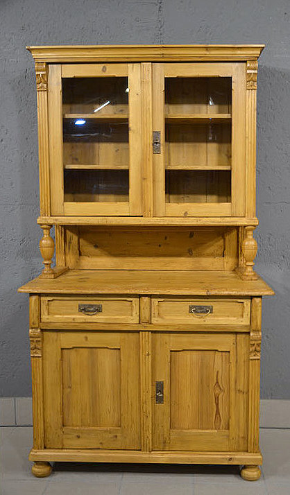 Antiker zierlicher Kuechenschrank aus der Gruenderzeit um 1880 aus massivem Kiefernholz restauriert zweiteilig mit verglasten Tueren Saeulen und offenem Mittelfach. Wir liefern zuverl&auml;ssig, kosteng&uuml;nstig und pers&ouml;nlich &ndash; deutschlandweit bis in Ihr Zuhause. Nach Terminvereinbarung k&ouml;nnen Sie dieses M&ouml;belst&uuml;ck gerne in unserem M&ouml;bellager in Bargfeld-Stegen besichtigen