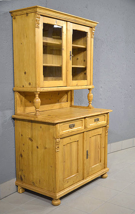 Linke Seitenansicht des zierlichen Kuechenschrankes aus massivem Kiefernholz mit harmonischer Linienfuehrung und stabiler Bauweise. Wir liefern zuverl&auml;ssig, kosteng&uuml;nstig und pers&ouml;nlich &ndash; deutschlandweit bis in Ihr Zuhause. Nach Terminvereinbarung k&ouml;nnen Sie dieses M&ouml;belst&uuml;ck gerne in unserem M&ouml;bellager in Bargfeld-Stegen besichtigen