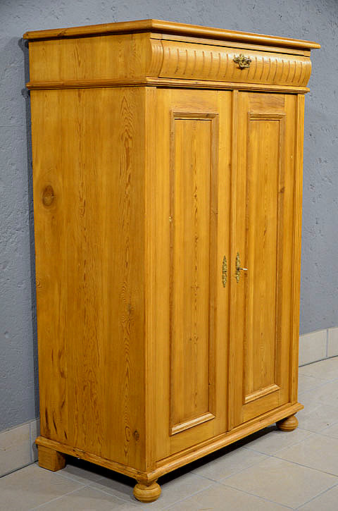 Linke Seitenansicht des antiken Gr&uuml;nderzeit-Vertikos aus D&auml;nemark, honigfarben gewachst, mit dekorativen Profilen.