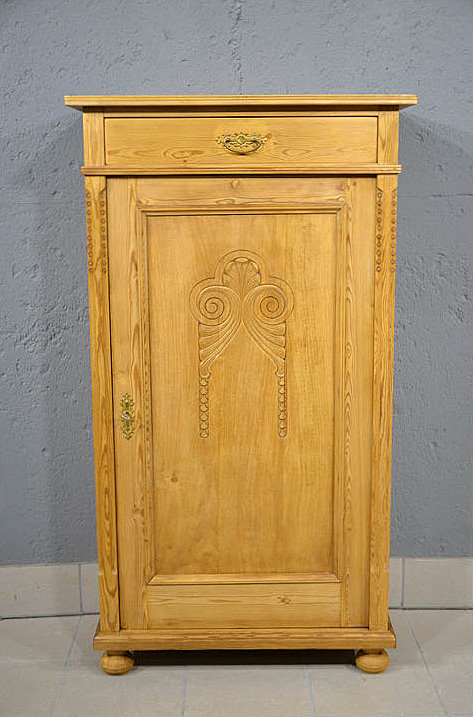 Antikes Jugendstil Vertiko aus Daenemark um 1900 aus massivem Kiefernholz restauriert mit einer Tuere, Schnitzerei und grosser Schublade im oberen Bereich. Wir liefern zuverl&auml;ssig, kosteng&uuml;nstig und pers&ouml;nlich &ndash; deutschlandweit bis in Ihr Zuhause. Nach Terminvereinbarung k&ouml;nnen Sie dieses M&ouml;belst&uuml;ck gerne in unserem M&ouml;bellager in Bargfeld-Stegen besichtigen