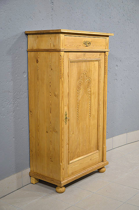 Linke Seitenansicht des schmalen Vertikos aus massivem Kiefernholz mit eleganter Linienfuehrung und platzsparender Bauweise. Wir liefern zuverl&auml;ssig, kosteng&uuml;nstig und pers&ouml;nlich &ndash; deutschlandweit bis in Ihr Zuhause. Nach Terminvereinbarung k&ouml;nnen Sie dieses M&ouml;belst&uuml;ck gerne in unserem M&ouml;bellager in Bargfeld-Stegen besichtigen