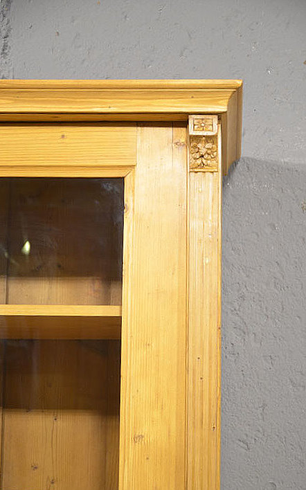 Kranzbereich der antiken gruenderzeit vitrine schlicht und harmonisch aus massivem Kiefernholz restauriert im warmen Honigton. Wir liefern zuverlässig, kostengünstig und persönlich – deutschlandweit bis in Ihr Zuhause. Nach Terminvereinbarung können Sie dieses Möbelstück gerne in unserem Möbellager in Bargfeld-Stegen besichtigen